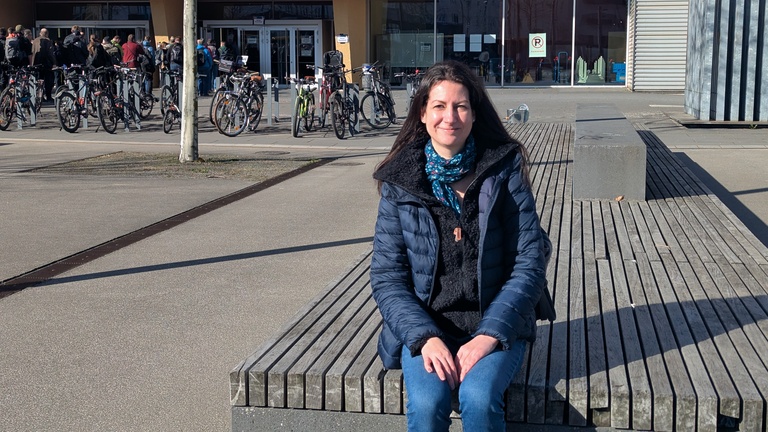 Ich auf einer Bank vor dem zentralen Hörsaal- und Seminar-Gebäude der TU Chemnitz