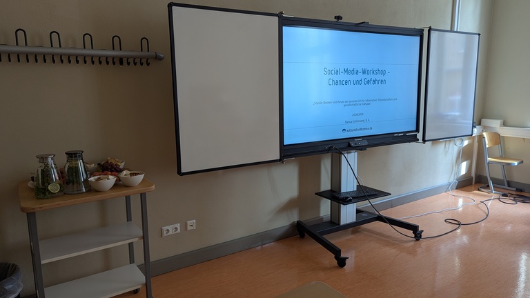 Smartboard, auf dem der Titel des Kurses zu lesen ist: „Social-Media-Workshop – Chancen und Gefahren“.